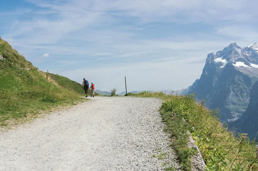 Vater und Sohn wandern auf einem Bergweg in den Schweizer Alpen