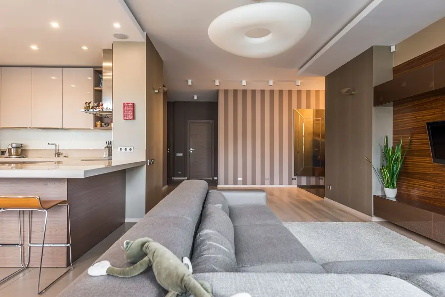 Helles Wohnzimmer mit Sofa und offener Küche